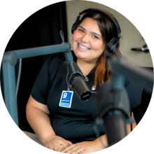 Woman with headphones sitting in front of mic